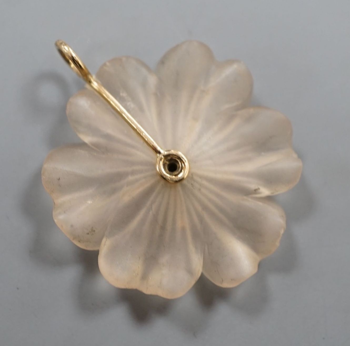 A yellow metal and diamond set frosted glass petal pendant, overall 33mm.